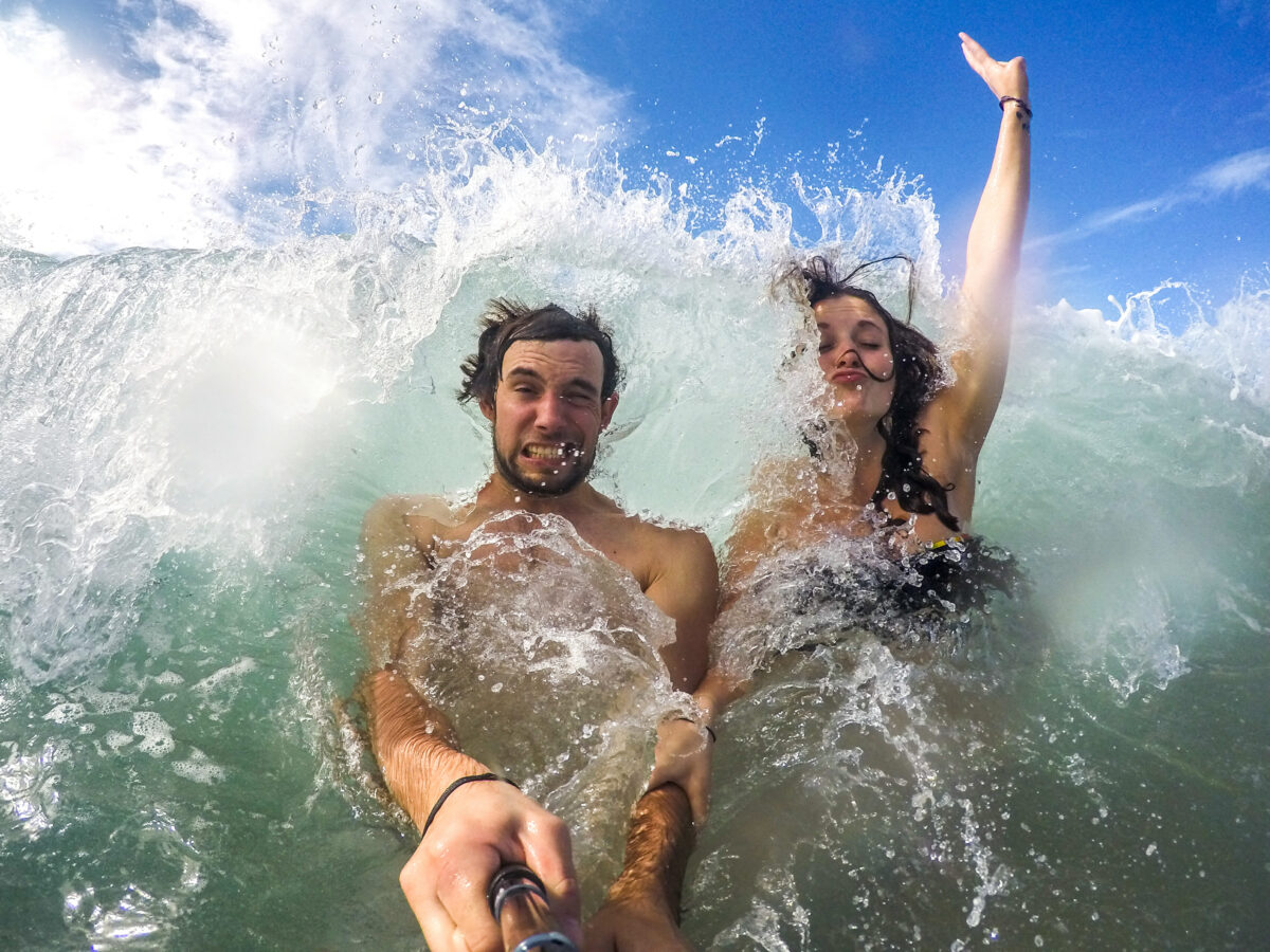 Jules et Maryne éclaboussé par une vague au costa rica 