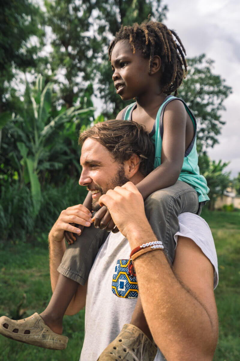 Photo d'un homme portant un enfant sur ses épaules en Tanzanie