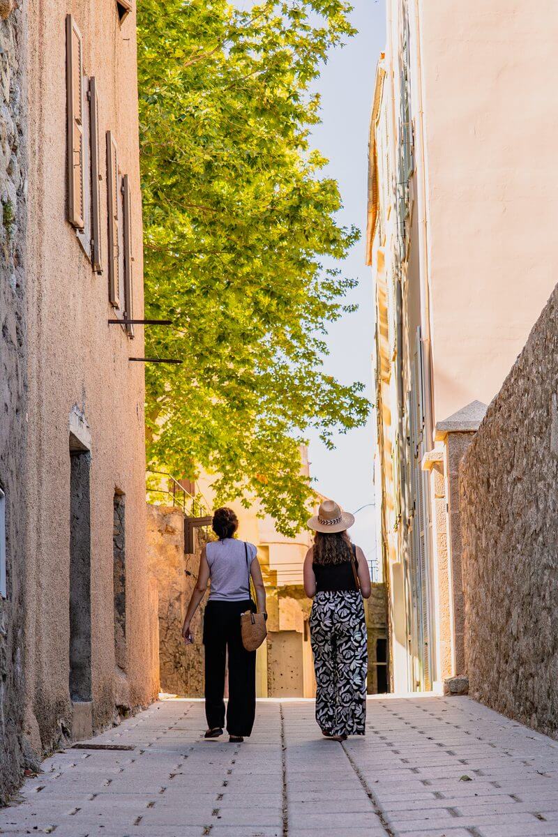 Photo de 2 personnes marchant dans une ruelle de la citadelle de Calvi